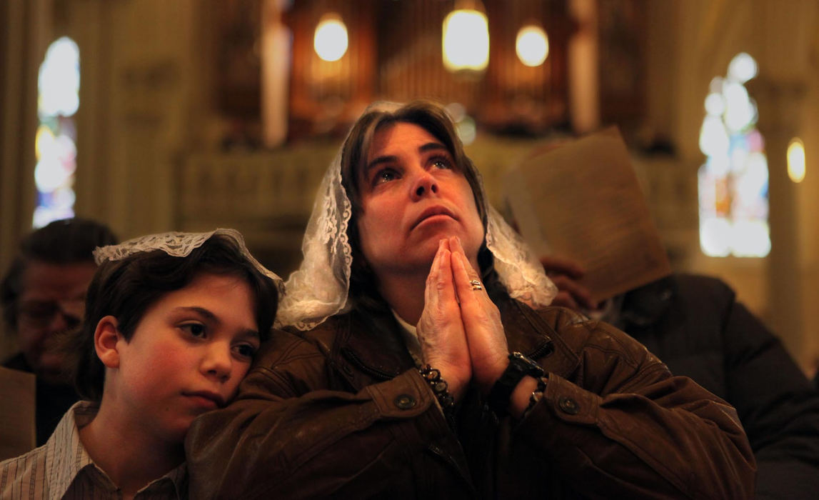 First Place, James R. Gordon Ohio Understanding Award - Gus Chan / The Plain DealerAnn Christopher sits with her daughter Elizabeth, 10, during a prayer service at St. Stephen Church.  St. Stephen's was one of the Cleveland churches in danger of closing during the Catholic Diocese downsizing.