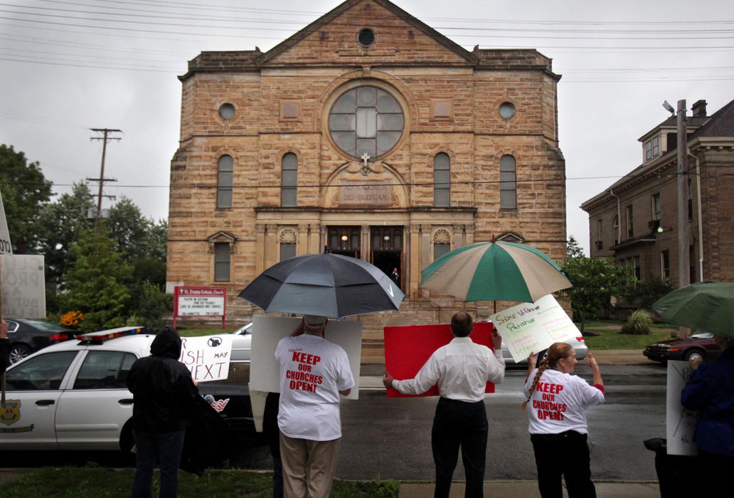 First Place, James R. Gordon Ohio Understanding Award - Gus Chan / The Plain DealerMembers of the group Endangered Catholics protest outside of St. Procop Church before the final mass .  The church closed it's doors for the final time after the morning service. 