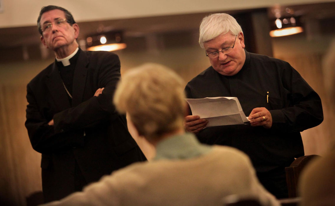 First Place, James R. Gordon Ohio Understanding Award - Gus Chan / The Plain DealerBishop Richard Lennon listens as Fr. Paul Rosing, of St. John the Baptist Church reads the court injunction prohibiting a group of protesters from occupying the church.