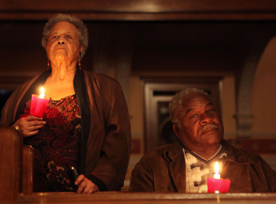 First Place, James R. Gordon Ohio Understanding Award - Gus Chan / The Plain DealerJane Skinner (left) and Johnnie Farmer hold candles during the Holy Saturday Vigil at St. Adalbert Church. 