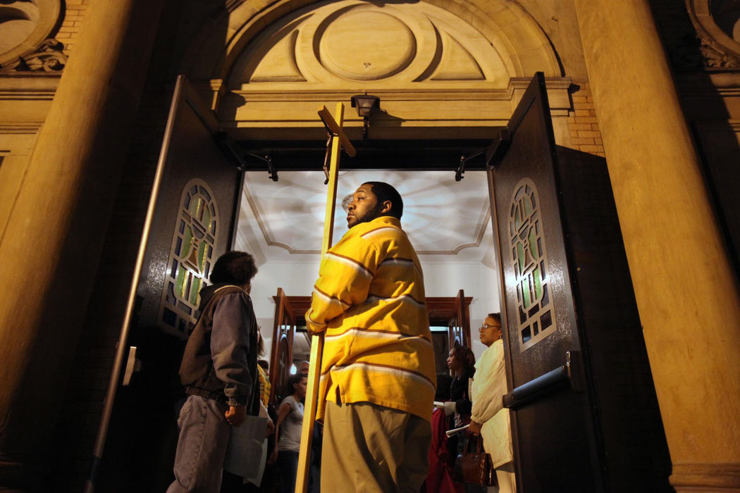 First Place, James R. Gordon Ohio Understanding Award - Gus Chan / The Plain DealerGeorge Gamble holds the cross in the doorway of St. Adalbert Church.  The church was conducting an all night prayer vigil in hopes that Bishop Richard Lennon would change his mind and keep the church open.  