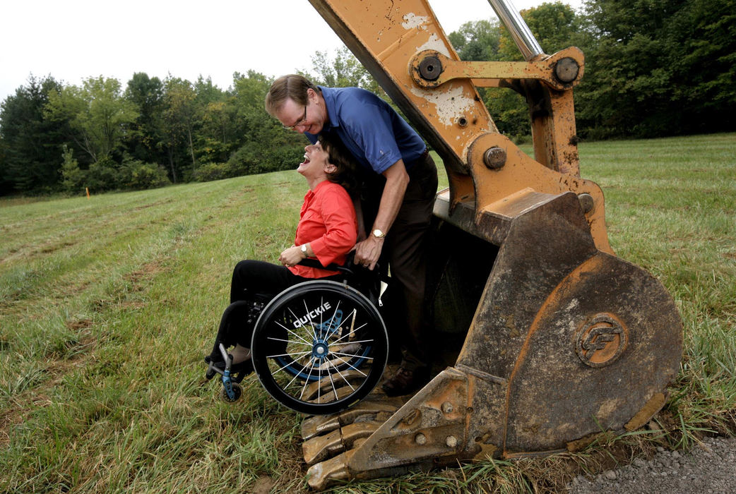 First Place, Photographer of the Year Large Market - Fred Squillante / The Columbus DispatchRosemarie Rossetti laughs as her husband, Mark Leder jokingly rolls her into the bucket of an excavator after  ground-breaking ceremonies for their new home. The 3,500-square-foot home will serve not only as the couple's residence but also as a "universal design living laboratory," showcasing the latest features in handicapped-accessible homes. Rossetti was paralyzed from the waist down in 1998, when a tree fell on her while she was bicycling.