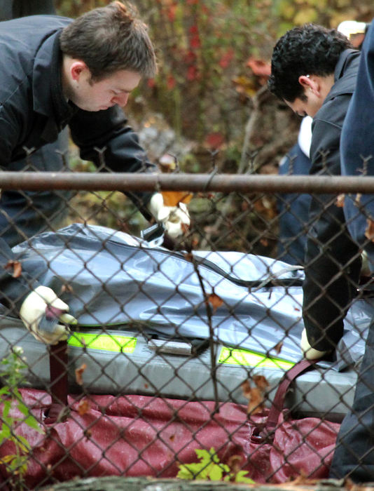 Third Place, Photographer of the Year Large Market - John Kuntz / The Plain DealerCuyahoga County coroners fasten straps around a body dug up from the back yard at the home of Anthony Sowell November 3, 2009 in Cleveland's east side. 