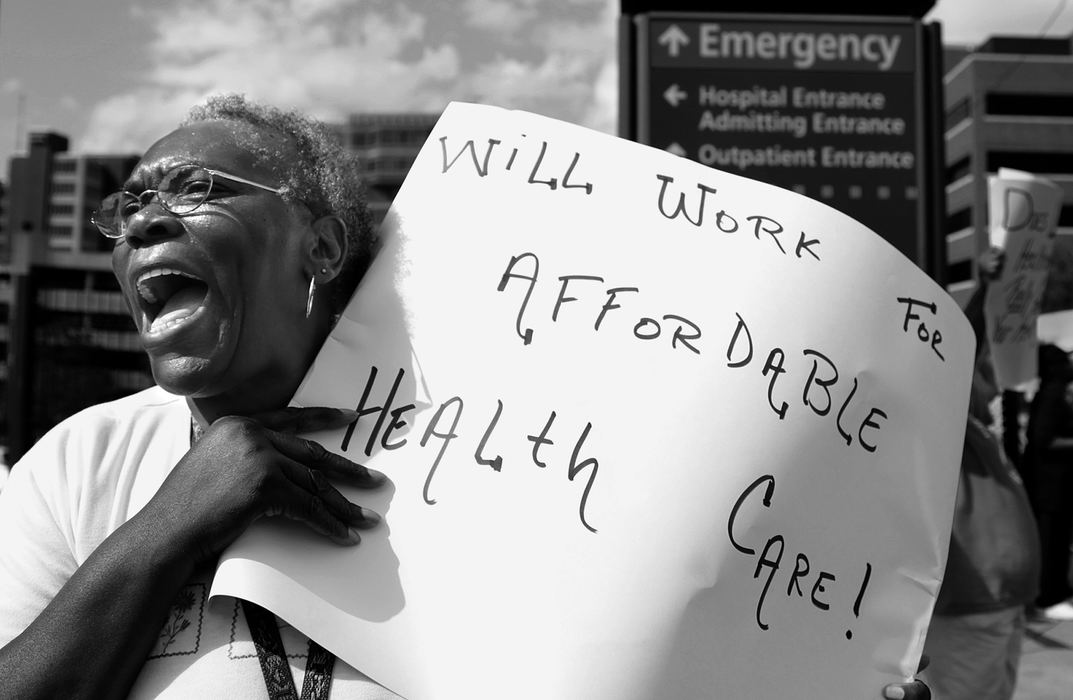 Award of Excellence, Photographer of the Year Large Market - Michael E. Keating / Cincinnati EnquirerVelma Sanders, a former healthcare worker who was forced to leave her job with a disability in 1989, supports healthcare reform.  She was supporting the cause along with other members of the Amos Project outside University Hospital. Sanders was part of a group of 15 supporters who carried signs and chanted for reform along Dr. Martin Luther King Blvd.  