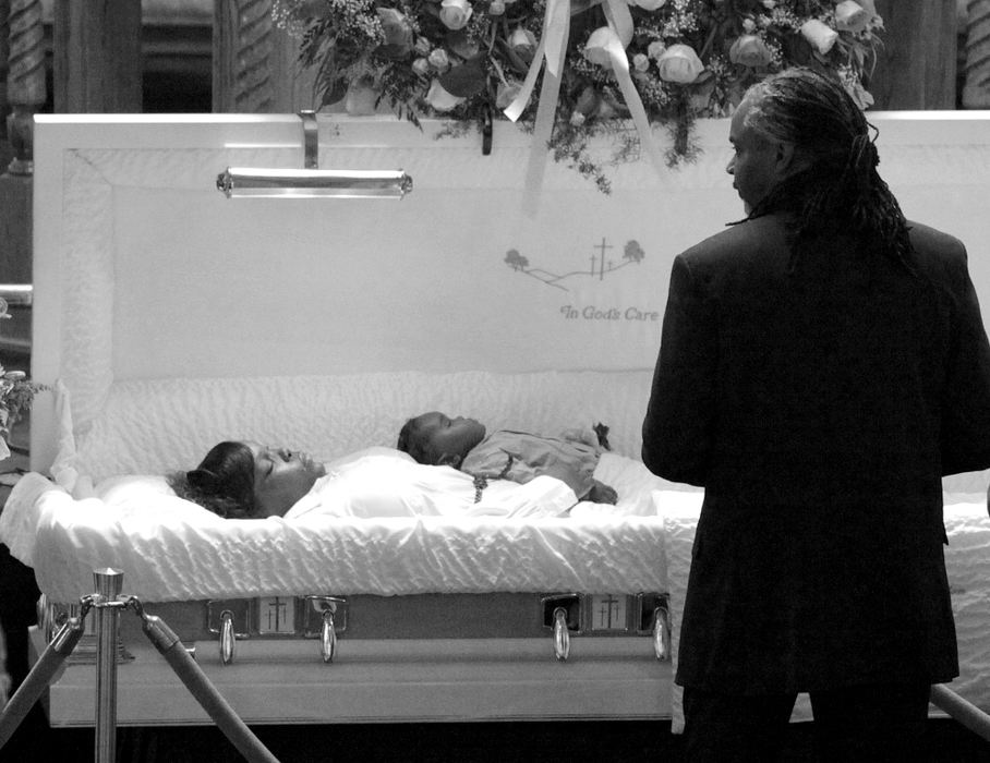 Award of Excellence, Photographer of the Year Large Market - Michael E. Keating / Cincinnati EnquirerPreacher and anti-violence advocate Rev. Damon Lynch, stands at the casket where Noelle and her son lay in repose. Shot dead were Noelle Washington, her 9-month-old son, Anthony Jones, and Sharailyn Wright, a 3-year-old girl for whom Washington was babysitting. A neighborhood reacts with a prayer vigil, emotional funeral services including a mime's tribute dance. The killer has not been caught. 