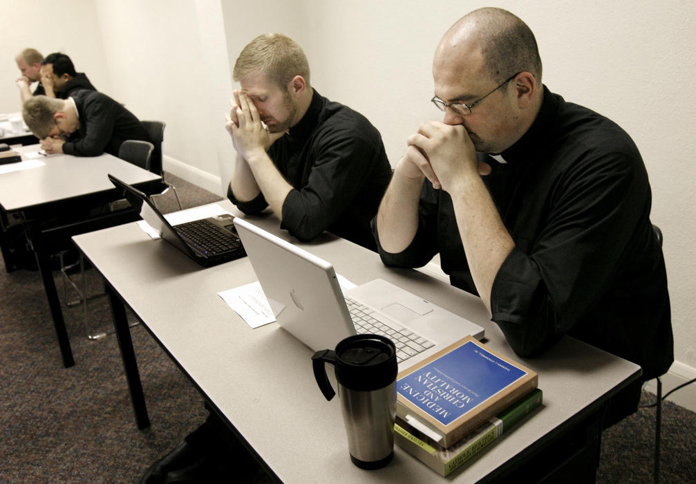 First Place, Photographer of the Year Large Market - Fred Squillante / The Columbus Dispatch At the beginning of a medical morality class, students say a prayer together. At far right is Deacon Robert Bolding. Ordained as deacon in 2008, Robert took a vow of celibacy and obedience. He has prayed daily about the sacrifices he will make as a priest: he will never marry or have children. 