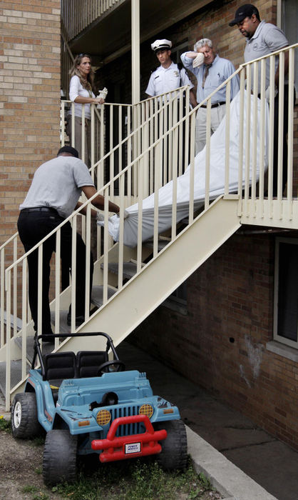 First Place, Photographer of the Year Large Market - Fred Squillante / The Columbus DispatchColumbus homicide detective James McCoskey wipes his brow as the body of a man is removed from an apartment. The man's 4-year-old son was found with the body, having been left alone in the apartment for several days after the man died and before the body was discovered.