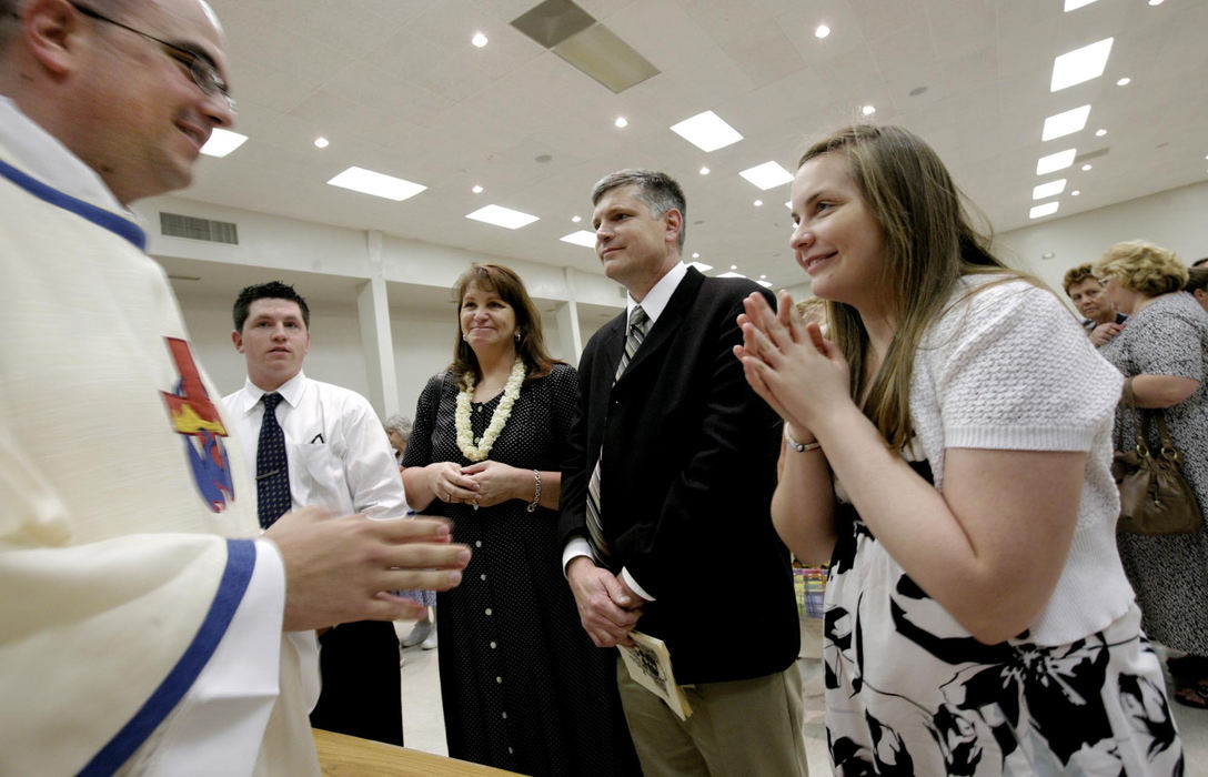 First Place, Photographer of the Year Large Market - Fred Squillante / The Columbus DispatchFather Robert Bolding (far left) smiles at his sister, Tricia, far right.  Bolding's family was first in a reception line to receive a blessing by the new priest. In front of Robert are,  (from left) his brother Nick, mom Patty, dad Al, and sister Tricia.