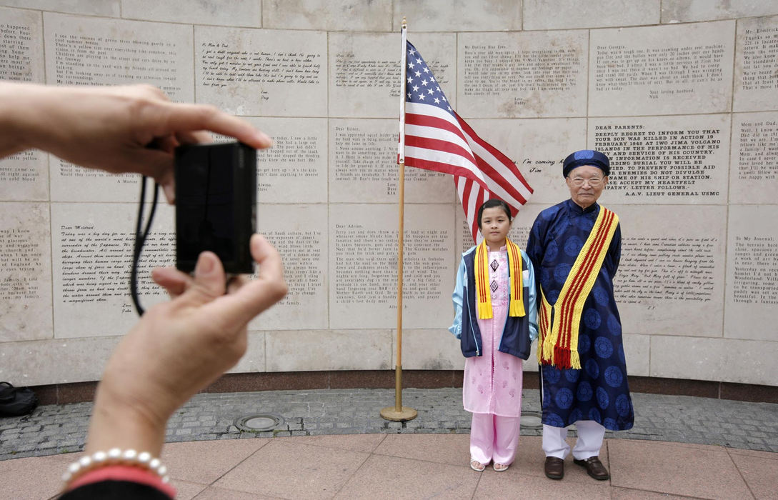 First Place, Photographer of the Year Large Market - Fred Squillante / The Columbus DispatchSophie Dang, 9, poses for a portrait with her grandfather, Phuong Dang, 83, in front of a curved limestone wall inscribed with actual correspondence sent home to families by soldiers at war. The wall is part of Ohio Veterans Plaza at the Ohio Statehouse. 