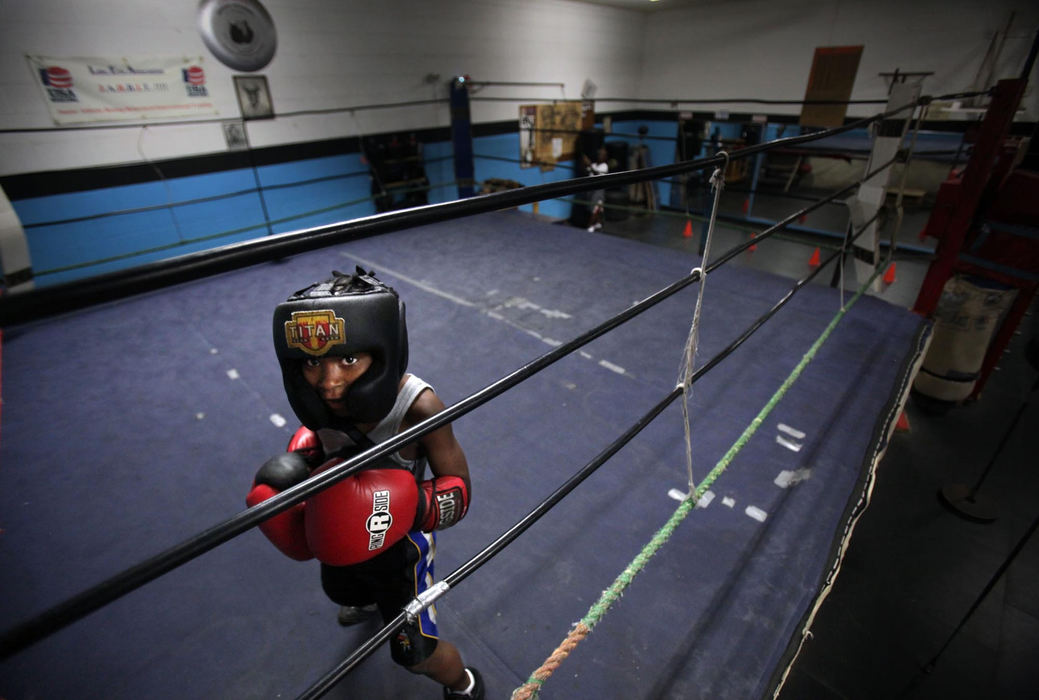 Second Place, Photographer of the Year Large Market - Gus Chan / The Plain DealerTai' Rez Jackson, 7, prepares to spar at the Salvation Army's Clint Martin Boxing Club.  The club is part of the many after school activities offered by the center to keep kids off the street.