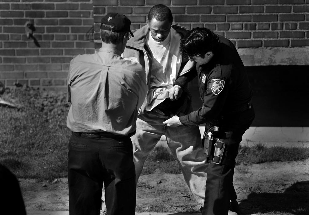 Second Place, Photographer of the Year Large Market - Gus Chan / The Plain DealerCuyahoga Metro Housing Authority police officer Clint Ovalle searches a suspect under the watch of CWRU social work instructor Mark Singer at CMHA's Lakeview Terrace property.