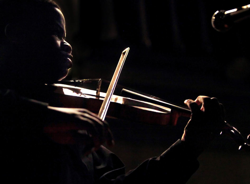 Third Place, Photographer of the Year Large Market - John Kuntz / The Plain DealerGetting the permission to move around the stage at the Cleveland School of the Arts auditorium paid off.  The solo violin opener by CSA student, Soloman Mathis, had him at the font edge of the stage where the lights fell off his face.  I moved in front of the stage and was able to capture the rim light around Soloman during his rendition of the National Anthem October 16, 2009 during the school's monthly arts assembly at the former Harry Davis Junior High building in Cleveland. JOHN KUNTZ  THE PLAIN DEALER  Soloman Mathes performs a solo rendition of the national anthem as the Cleveland School of the Arts orchestra prepares to play for students