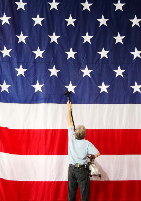 Third Place, Photographer of the Year Large Market - John Kuntz / The Plain DealerGary Jurist, owner of RCS Corp. in Cleveland, steams out the folds in a giant U.S. flag July 22, 2009 that will be the backdrop for President Barack Obama's visit to Shaker Heights High School tomorrow.  Jurist's company is responsible for the staging, sound and lights for the president's visit.  