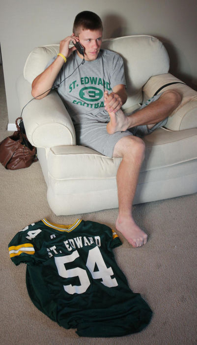 Third Place, Photographer of the Year Large Market - John Kuntz / The Plain DealerIan Stuart talks on the phone to a friend with his St. Edward High School football jersey on the floor after showing his grandmother and aunt with Eagle pride August 18, 2009 at his Rocky River home.  Ian was second in line to get his jersey because he wanted to make sure to get number 54, the same number he wore with St. Thomas Moore football.    