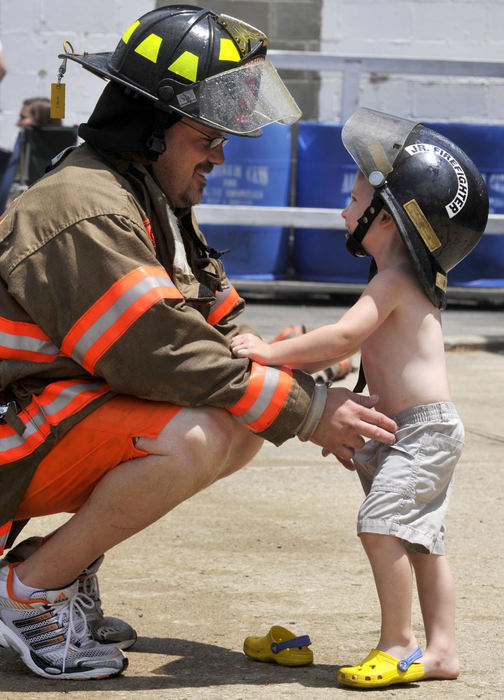 First Place, Photographer of the Year Small Market - Bill Lackey / Springfield News-SunBen Oburn, a Christiansburg firefighter, helps his son, Brantlee, 3, get his sandle back on as Ben takes a break from the firefighter waterball competition in Christiansburg, July 5, 2009. 