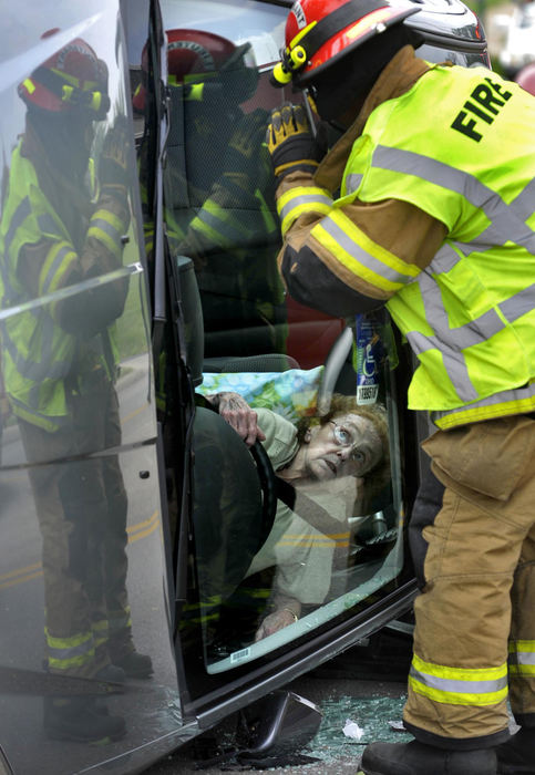 First Place, Photographer of the Year Small Market - Bill Lackey / Springfield News-SunA woman looks up at members of the Springfield Fire Division as she waits to be rescued from her overturned car, May 28 2009 on McCreight Ave. The woman apparently lost control of her car striking a street sign and tree which flipped the car on its side. She was transported to the hospital with non-life threatening injuries.  