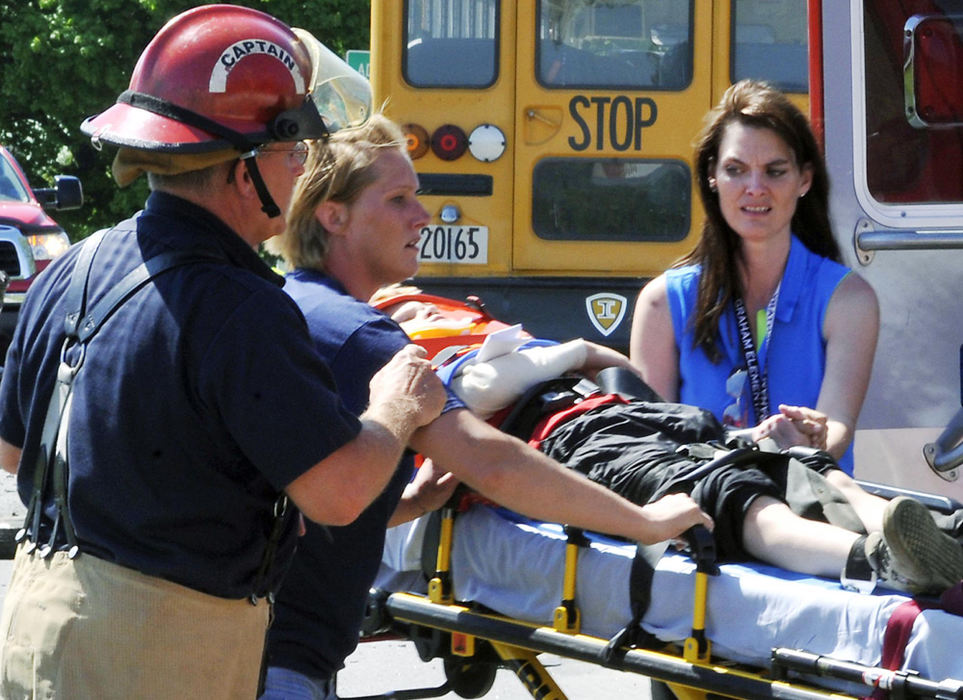 First Place, Photographer of the Year Small Market - Bill Lackey / Springfield News-SunAn injured student is rushed to a medic unit after the bus he was riding on collided head-on with a mini van on Ohio 36 in Champaign County. 