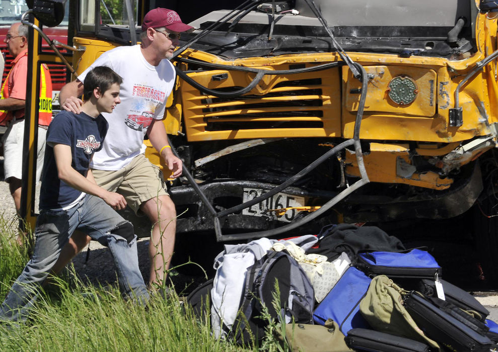 First Place, Photographer of the Year Small Market - Bill Lackey / Springfield News-SunA parent leads his uninjured son past the bus he was riding on when in crashed head-on into a mini-van killing the van's driver and passenger on Ohio 36 in Champaign County. 
