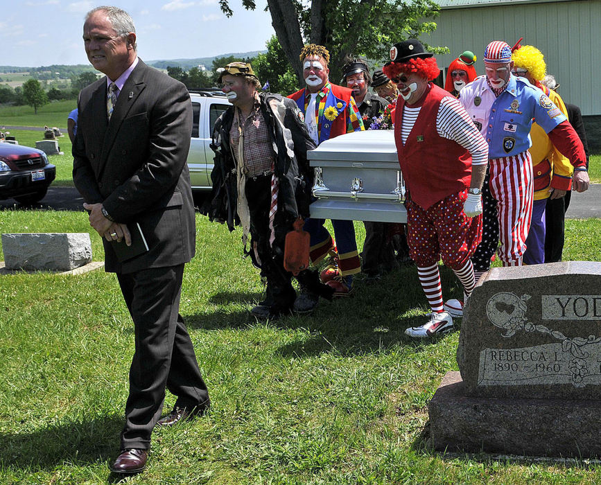 Second Place, Photographer of the Year Small Market - Marshall Gorby / Springfield News-SunBellefontaine's Hi-Point Church of Christ Pastor Mike Sandlin leads eight pallbearers dressed in full clown regalia at the funeral of Norman Thompson, life member of Antioch Shrine Funster Clown Unit, at Fairview Cemetery in West Liberty on May 29.  