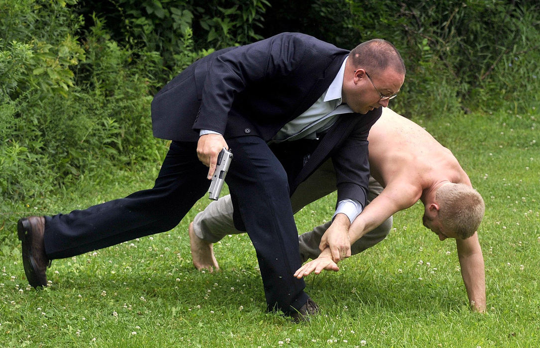 Second Place, Photographer of the Year Small Market - Marshall Gorby / Springfield News-SunClark County Sheriff's Sgt. Chris Clark takes down Rueben Finley, 22, after Clark found him hiding under a truck cap during a drug raid behind 6080 Nagley Road on July 28.