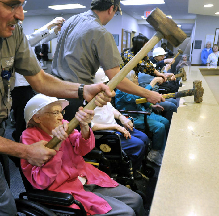 First Place, Photographer of the Year Small Market - Bill Lackey / Springfield News-SunMargaret Smith, a resident at Oakwood Village retirement center, swings a sledge hammer into the counter at the nurses station in the skilled care area, March 25, 2009, with a little help from staff member, Doug Hayden. Several of the residents started the demolition to tear down the nurses station after administrators at the center determined the station created a physical and psychological wall between the residents and the nurses who are taking care of them.  