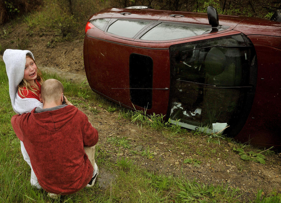 Second Place, Photographer of the Year Small Market - Marshall Gorby / Springfield News-SunThe driver and a child passenger console each other after the vehicle they were riding in flipped into a ditch on the entrance ramp to Ohio Route 4 from US 40, May 13, 2009. Both people escaped unharmed. Springfield police and Ohio State patrol personnel responded to the scene.