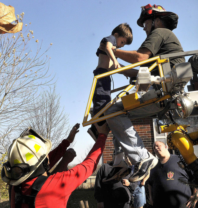 Second Place, Photographer of the Year Small Market - Marshall Gorby / Springfield News-SunEnon firefighter, Bob Wagner hands down Danny Richardson, 6, after rescuing the little boy who had climbed a 30 foot tree in his Grandmother's front yard at 368 Lammes Lane on Saturday, Nov. 7. 