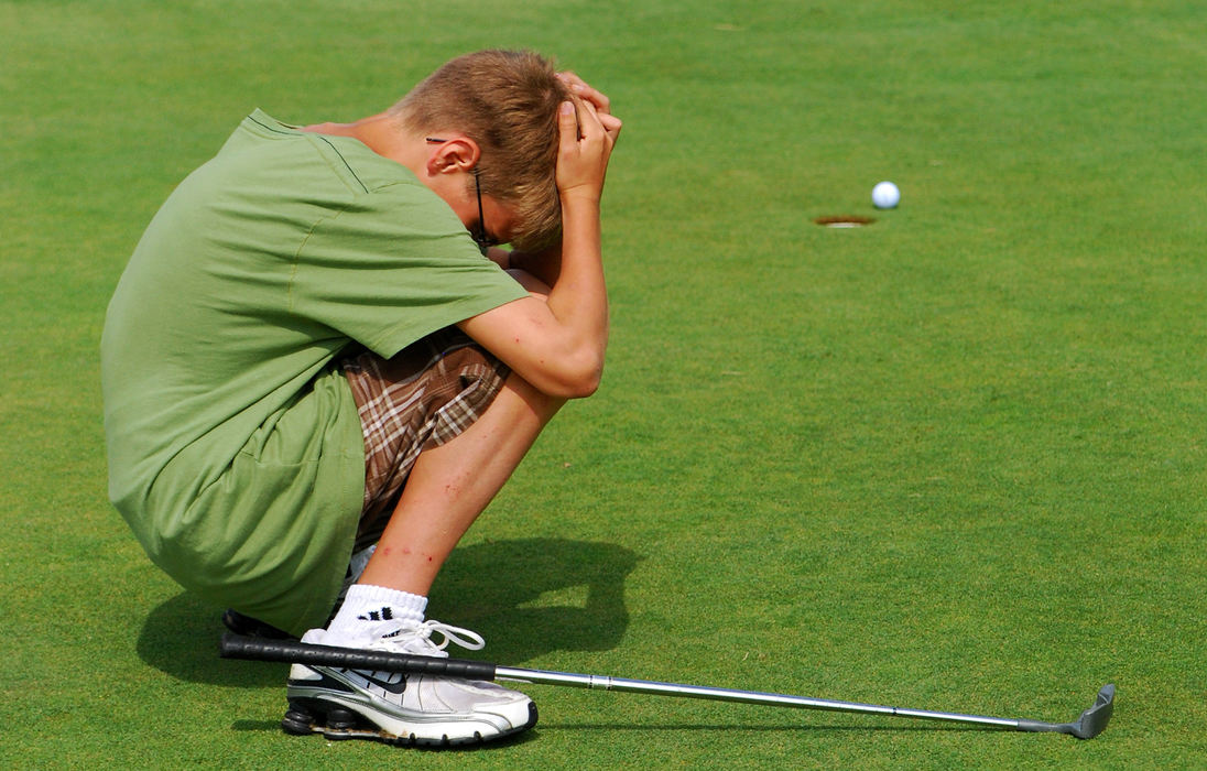 Third Place, Photographer of the Year Small Market - Tessa Bargainnier / Kent State UniversityCollin Lenhart, 12, crouches in disappointment after watching his ball narrowly avoid the hole while practicing on the putting green during Double Eagle golf camp at the Wapakoneta Country Club. 