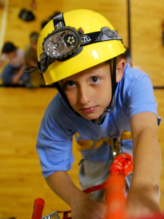 Third Place, Photographer of the Year Small Market - Tessa Bargainnier / Kent State UniversityHunter Wildermuth, 8, practices fire escape with Wapakoneta Firefighters Doug Hill and Eric Snapp at the Wapakoneta Family YMCA during safety week for the kids summer camp program. Wildermuth steps cautiously as he climbs down a fire escape latter hanging from the balcony down to the gym floor as students watch from below. 
