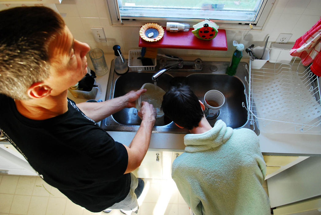 Third Place, Photographer of the Year Small Market - Tessa Bargainnier / Kent State UniversityJen and Tom go through their daily morning routine of drinking wheat grass and washing the dishes. Jen places her cup in the sink drain for support and sips from a straw. She said she learned this trick after cleaning up hundreds of spilled drinks.