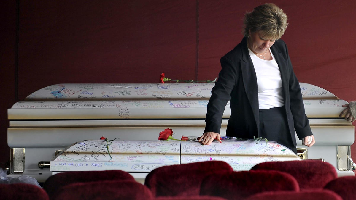 First Place, Photographer of the Year Small Market - Bill Lackey / Springfield News-SunA family member touches the top of Cassandra Karg's signed casket as she leaves following funeral services for Cassandra and her three cousins, Nathan Skaggs, Breonna Snelling and Patrick Snelling, March 28, 2009 at Spring Grove Cemetery. The four children were killed in a mobile home fire in St. Paris. 