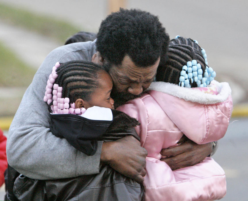Award of Excellence, Spot News (under 100,000) - Scott Heckel / The RepositoryGerald Adkins embraces his two daughters, Shekahana Adkins, 8,  (left) and Shekiah Adkins, 10, after a fire ripped through their home in Canton. Both children managed to escape but their brother, Azariah Adkins, 5, died in the blaze.