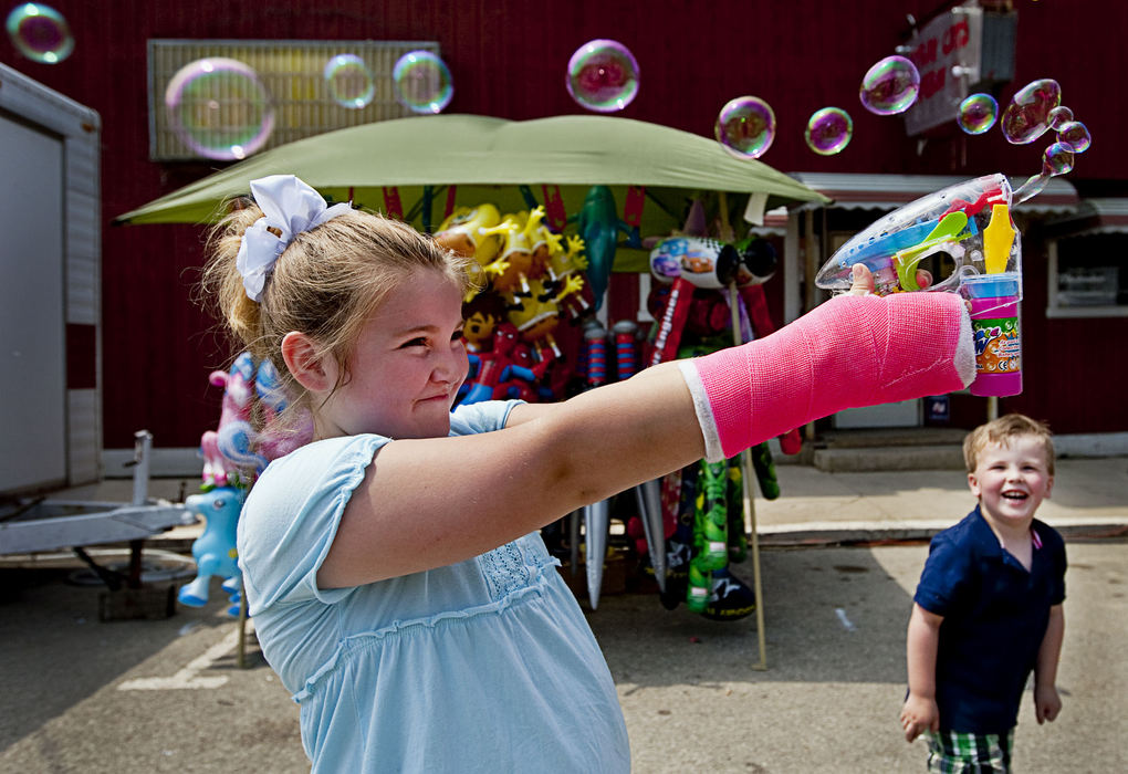 First Place, Student Photographer of the Year - Diego James Robles / Ohio UniversityThe oldest girl in the Little Miss pageant, Hannah Lanning, 8, fires a bubble-gun to amuse her step-brother Leum, 4, during the New Straightsville Moonshine Festival, on May 23.  