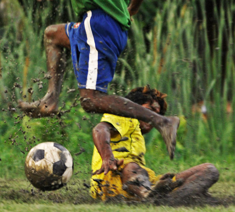 Third Place, Student Photographer of the Year - Laura Torchia / Kent State UniversityMithun, 19, of the Sudder Street Football Club, checks the ball from his opponent in game one of tournament play.  The Sudder Street club is a group of homeless “slumdogs” from India’s Sudder Street who compete in a local league of barefoot mud football.