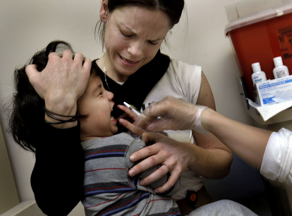 Second Place, Team Picture Story - Fred Squillante / The Columbus DispatchJacob Bednar, 3, being held by his mom, Sarah Bednar, is an unwilling recipient of the H1N1 nasal vaccine, Dec. 11, 2009 at Lifecare Alliance in Columbus. 