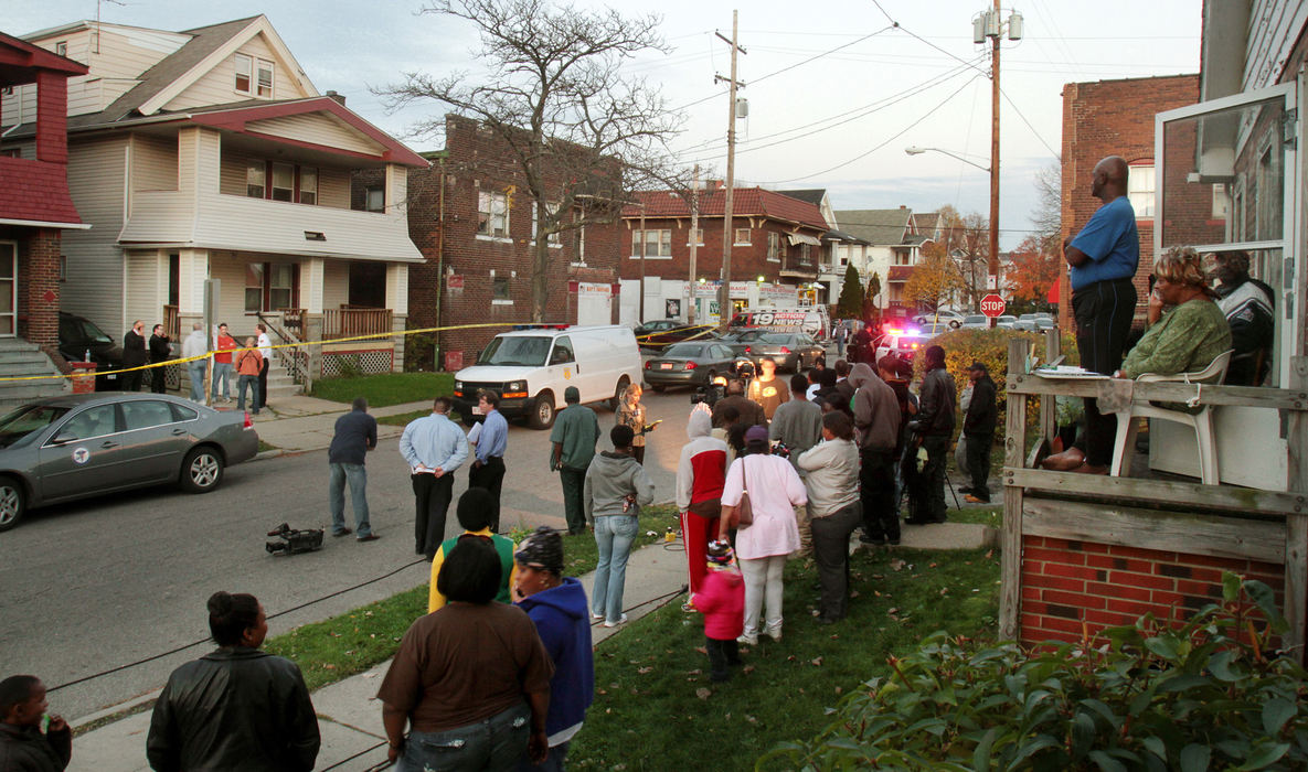 First Place, Team Picture Story - John Kuntz / The Plain DealerA crowd gathers as the grisly search on Imperial Avenue progresses.  Neighbors noticed a stench coming from the vicinity of the house. 