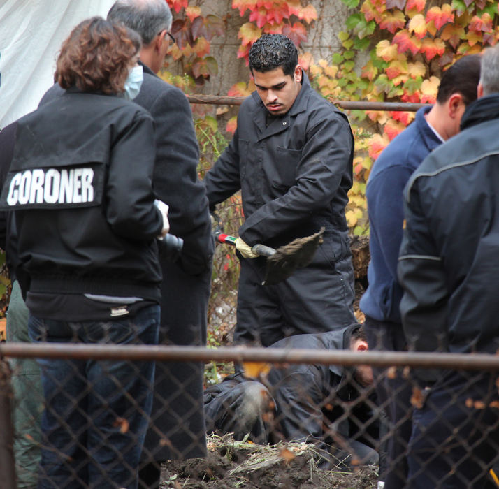 First Place, Team Picture Story - John Kuntz / The Plain DealerCoroners dig in the backyard at the home of Anthony Sowell as they exhume another body. On this night, eight more bodies were found.  