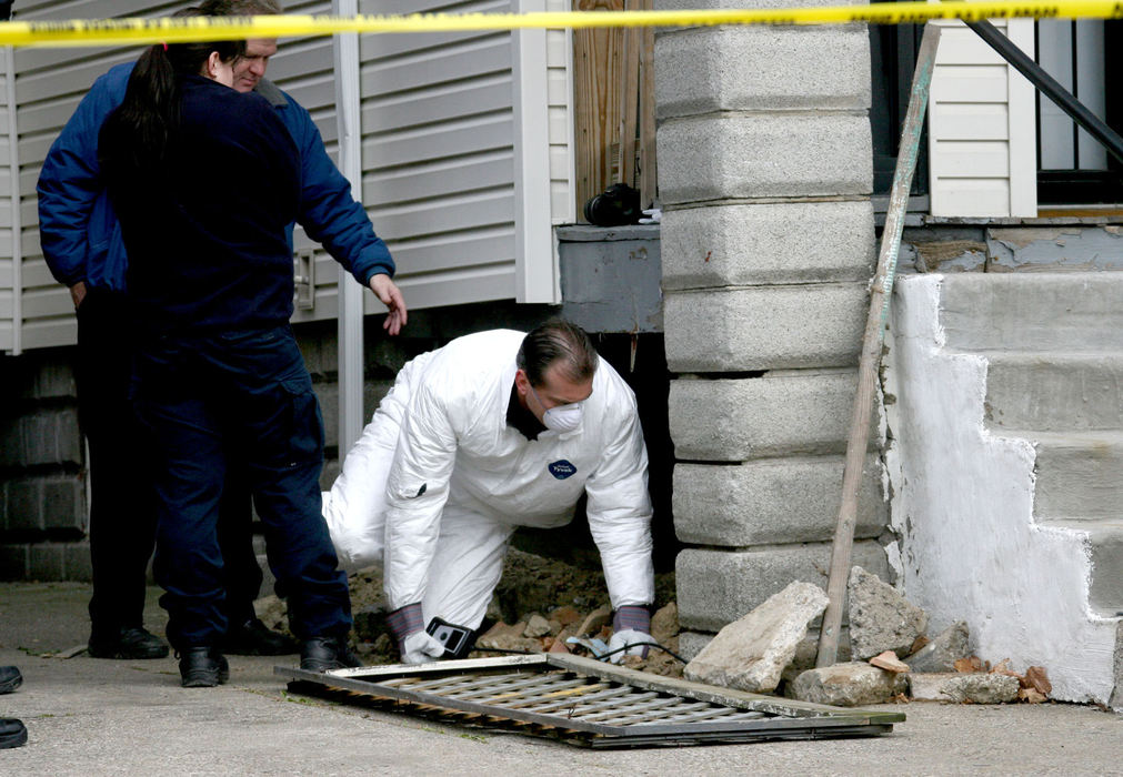 First Place, Team Picture Story - Marvin Fong / The Plain DealerPolice examine an area below the front steps of the Sowell home to look for evidence of more bodies. 