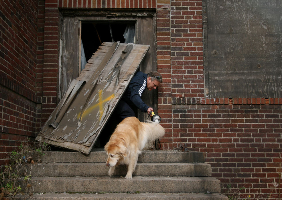 First Place, Team Picture Story - Gus Chan / The Plain DealerAs the search for more bodies continues, a Cleveland firefighter works with a cadaver dog at the former Lafayette Elementary School, a few blocks from the home of Anthony Sowell. 