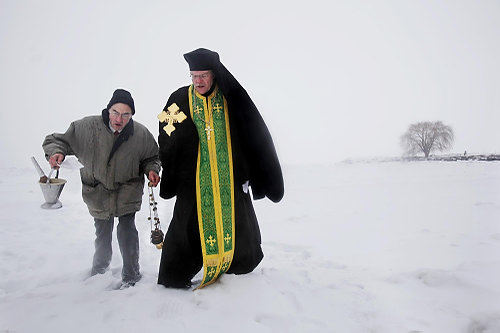 First Place, Feature - Gus Chan / The Plain DealerThe Rev. John Henry of St. Herman House of Hospitality, assisted by John Colton, walks along the icy shore of Lake Erie after the blessing of the waters , the Feast of the Epiphany. The annual ritual is performed at Edgewater Park.