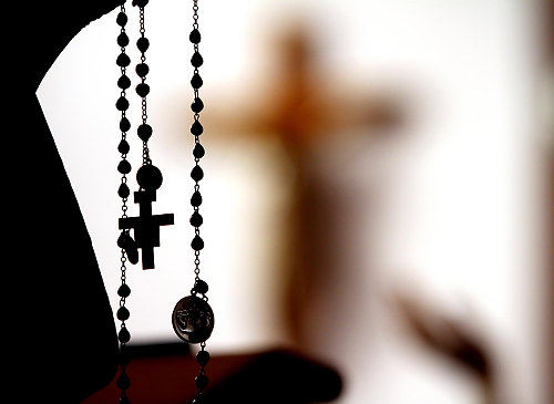 First Place, Feature Picture Story - Lisa DeJong / The Plain DealerSister Christina raises her hands up while holding her Rosary as she chants in the chapel. Nuns keep vigil around the clock. 