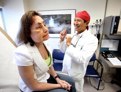 Second Place, Feature Picture Story - Lisa DeJong / The Plain DealerDr. Risal Djohan, a Cleveland Clinic plastic surgeon, looks over Connie Culp's transplanted face for signs of rejection and infection at a checkup in September. Connie's face muscles are slowly learning to smile, matching her sense of humor. And just as always, Connie makes him laugh. Months ago, he told her that she would look better than before. "Well this time, " she told him, "don't forget the boobs." 