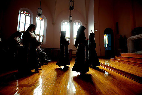First Place, Feature Picture Story - Lisa DeJong / The Plain DealerThe Poor Clare Sisters appear to float as they walk towards the altar and prepare to kneel in a private chapel called The Choir where they pray several times a day in their cloistered monastery. The nuns live at the home of the Poor Clare Colettine Nuns, a medieval order of cloistered Roman Catholic sisters formed in the early 13th century by St. Clare of Assisi. The starkness of the images try to emulate the simplicity of their lives. Vows of simplicity, poverty, chastity, obedience and enclosure mark their outward attributes. Prayer and reverential silence fill their inner life. 