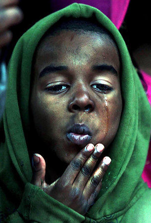 First Place, General News - Ernest Coleman  / The Cincinnati EnquirerEric Sheils, 6 wipes tears from his face near the end of a Prayer vigil for his mother Kelli Walton who was killed bye her boyfriend. As she held her three children in her arms as she stood in her front door of her apartment.