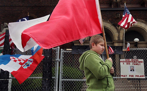 Second Place, News Picture Story - Gus Chan / The Plain DealerPatrick Bialek, 10, of North Royalton, holds the Polish flag during prayer service outside the closed St. Casimir Church.