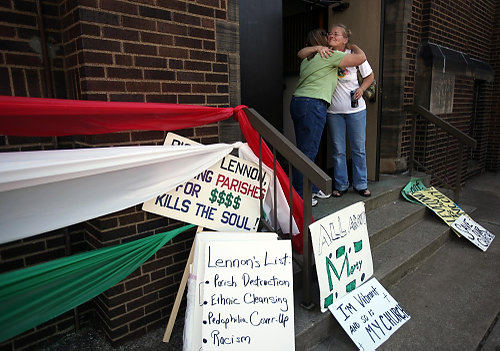 Second Place, News Picture Story - Gus Chan / The Plain DealerAngela Dohar-Szucs, left, and Heidi Kocskar, right, hug outside St. Emeric Church during the final service.  After more than a year of protests, the Hungarian Catholic church was the final church of fifty to close it's doors as part of the diocesan downsizing.