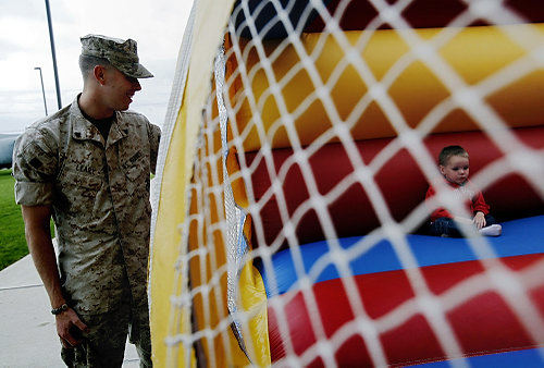 First Place, News Picture Story - Eric Albrecht / The Columbus DispatchCorporal Joseph Leary watches his son Jack 2 sit inside the bounce house sponsored by the local Amvets post.