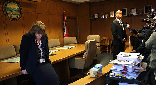 First Place, James R. Gordon Ohio Understanding Award - Gus Chan Gus Chan / The Plain DealerClerk of the Board Jeanne Schmotzer hangs her head as commissioner Peter Lawson Jones gives an interview after the final meeting of the Cuyahoga County Commissioners on Dec. 2, 2010.  