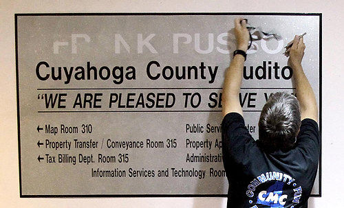 First Place, James R. Gordon Ohio Understanding Award - CHUCK CROW / The Plain DealerWes Liptack, a sign painter for Cuyahoga County, removes Frank Russo's name from the sign in the third-floor lobby of the auditor's office.  