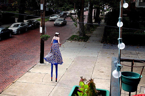 First Place, Photographer of the Year/Large Market - Lisa DeJong / The Plain DealerStiltwalker Julia Pankhurst makes her way down Murray Hill Road, practicing her stilt walking. Pankhurst, who has walked on stilts for years, says that these particular stilts make her about ten feet tall. Pankhurst is seen often at local parades. 